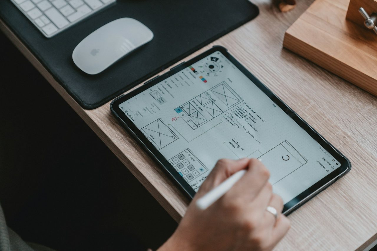 Hand sketching an app wireframe on a tablet